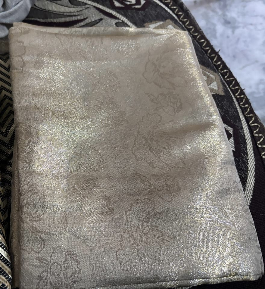 Pale ivory shimmery floral cloth, identified by the founder as brocade