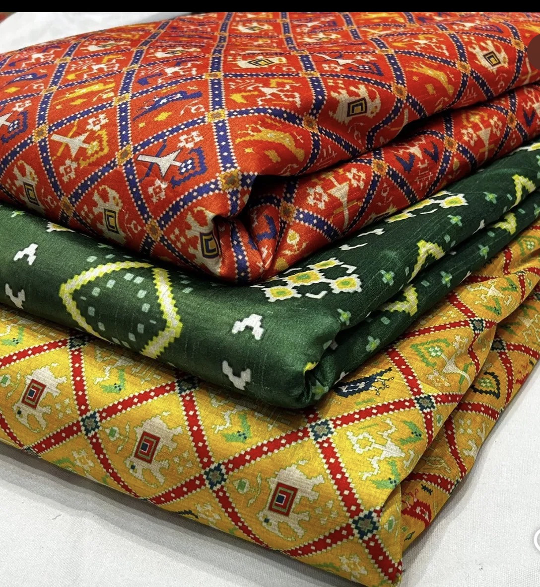Folded colorful geometric fabrics identified by the founder as Patola